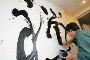 a man painting a tree on a wall at Park Hotel Tokyo in Tokyo