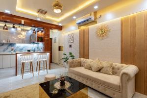 a living room with a couch and a kitchen at Goa Riviera in Goa