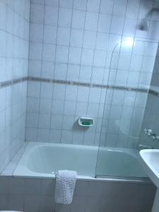 een witte badkamer met een bad en een wastafel bij Regency Bombal Apartments in Mendoza