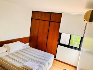 een kleine slaapkamer met een bed en een raam bij Regency Bombal Apartments in Mendoza +7 foto's