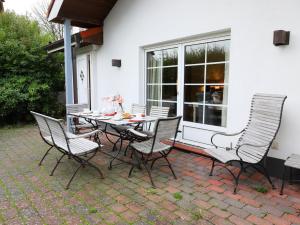 Una mesa y sillas en un patio. en Kampstraße 1, Bungalow, en Westerland