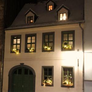 Una casa blanca con luces navideñas en las ventanas. en Altstadtbleibe, en Naumburg