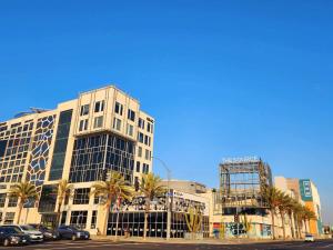 a tall building with palm trees in front of a street at Charming Bedroom Near Disney Land, Orange County in La Palma +11 photos