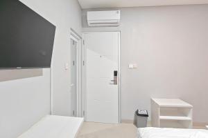 a white room with a sliding glass door and a bed at Urbanview Green Lake Sunter Residence in Jakarta