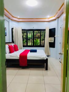 a bedroom with a bed with red pillows and a window at EntireHouse n Panglao FastWiFi AC HotShowers Netflix in Dauis