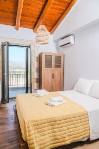 a bedroom with a large bed and a balcony at Emily Maria Fine Living in Filakí