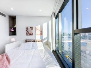 a bedroom with a white bed and a large window at Riverfront 2 Bedroom Apt in Brisbane City with Parking in Brisbane +31 photos