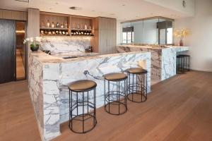 a kitchen with a marble counter and bar stools at Riverfront 2 Bedroom Apt in Brisbane City with Parking in Brisbane