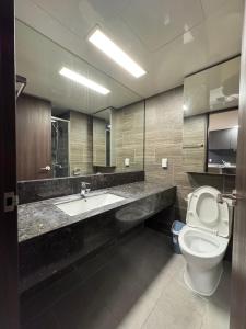 a bathroom with a toilet and a sink and a mirror at The Hide City in Jeju