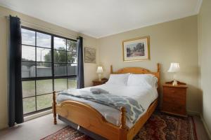 a bedroom with a bed and a large window at Three Bedroom Sweet Retreat in Coburg in Melbourne +1 photo