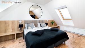 a bedroom with a large bed and a mirror at Wonder Home - Domki Hillside tuż przy stoku narciarskim - na terenie kompleksu plac zabaw i zewnętrzna siłownia, sklep, parking in Karpacz