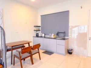 a kitchen with a table and a table and chairs at The Apple Suites Melaka in Melaka +25 photos