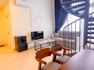 a living room with a couch and a tv at The Apple Suites Melaka in Melaka