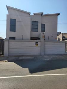 a white building on the side of a street at Park Q Residence in Pimville