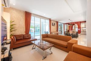 ナ・ジョムティエンにあるMagenta Grand House Pool Villa Pattayaのソファ2つとテーブルのあるリビングルーム