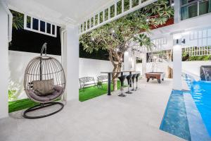 ナ・ジョムティエンにあるMagenta Grand House Pool Villa Pattayaのブランコとスイミングプール付きの客室です。
