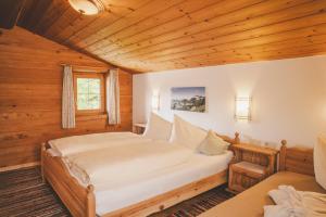 a bedroom with a bed in a wooden room at Demeterhof Knolln in Söll