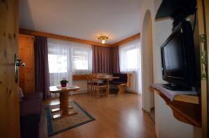 a living room with a television and a dining room at Haus Pinnistor in Neustift im Stubaital