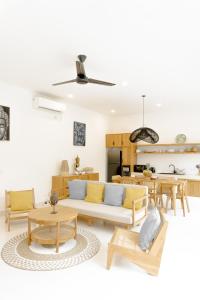 ein Wohnzimmer mit Couch und Tischen in der Unterkunft Casa Luna Villa in Kerobokan