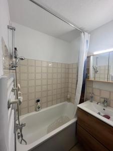 a bathroom with a bath tub and a sink at les Loulous Réallon in Réallon