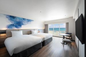 a hotel room with a bed and a desk and a window at Grand Mercure Okinawa Cape Zanpa Resort in Yomitan
