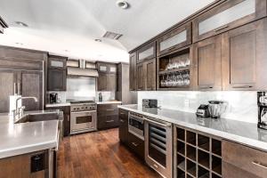 uma grande cozinha com armários de madeira e electrodomésticos de aço inoxidável em Scottsdale - 6924 E Mariposa Dr em Scottsdale