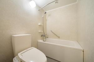 a white bathroom with a toilet and a shower at Grand Mercure Okinawa Cape Zanpa Resort in Yomitan