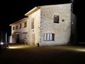 - un grand bâtiment en pierre la nuit avec une lumière dans l'établissement Cases Ruralmorella, à Morella