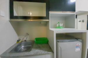 uma pequena cozinha com pia e geladeira em Comfort and Cozy Studio Student Castle Yogyakarta Apartment By Travelio em Seturan mais 4 fotografias