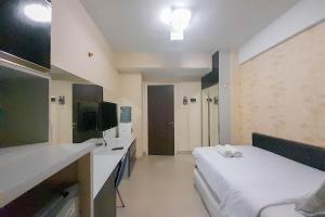 um quarto de hotel com duas camas e uma TV em Comfort and Cozy Studio Student Castle Yogyakarta Apartment By Travelio em Seturan