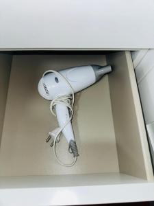 a white hairdryer in a box with at One Room Apartment Ptm 3 in Bucharest