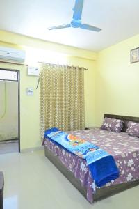 a bedroom with a bed and a ceiling fan at Vaidehikunj Homestay in Ayodhya