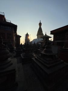 a group of temples with the sun setting in the background at Roommates by MaybeMars in Kathmandu +13 photos