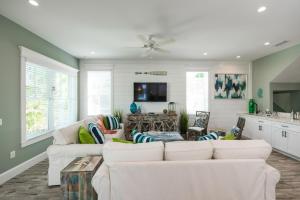 een woonkamer met witte banken en een keuken bij Daiquiri Deck in Anna Maria