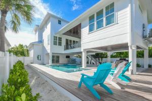 een huis met een zwembad en twee blauwe stoelen bij Daiquiri Deck in Anna Maria