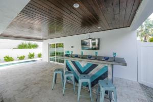 een patio met een bar met krukken en een tafel bij Daiquiri Deck in Anna Maria