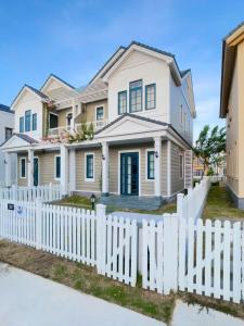 a white picket fence in front of a house at NOVAWORLD PHAN THIET SUNRISE VIILLA 4pn in Bình Tú