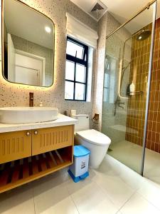 a bathroom with a sink and a toilet and a shower at NOVAWORLD PHAN THIET SUNRISE VIILLA 4pn in Bình Tú