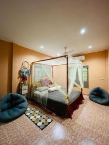 una camera con un letto a baldacchino e due sedie di Beachfront bungalow south of Phuket a Phuket