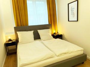 a bed with white sheets and pillows in a bedroom at 70qm Apartment in Viersen zentral gelegen mit hohen Decken - BEUYS Apartments - Viersen in Viersen