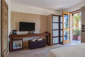 a bedroom with a tv and a bed and a fireplace at Vallegrande Nature Resort by Geocharme in Cefalù