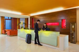 a man and woman standing at a counter in a lobby at Mamaison Residence Diana in Warsaw
