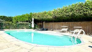 a swimming pool with two chairs and a table at Rendez-vous en Provence -10 personnes- duo de gîtes- piscine privée - clim in Cheval-Blanc