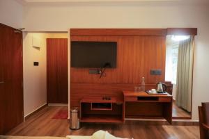 a living room with a television on a wooden wall at Silver cascade in Devikolam