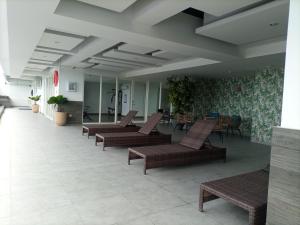 a row of chairs and tables in a lobby at Comfort Studio at 10th Floor Mataram City Apartment By Travelio in Kejayan