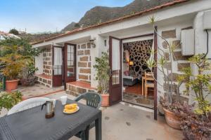 a patio with a table and chairs in front of a house at Casa Rural La Cuadra in Hermigua