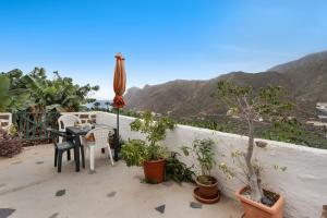 a patio with a table and chairs and plants at Casa Rural La Cuadra in Hermigua