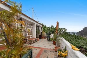 a balcony of a house with bananas and plants at Casa Rural La Cuadra in Hermigua