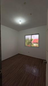 an empty room with a wooden floor and a window at Reymen's Transient in Bacolor