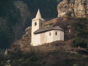 uma pequena igreja branca no lado de uma montanha em Pension Rita em Silandro